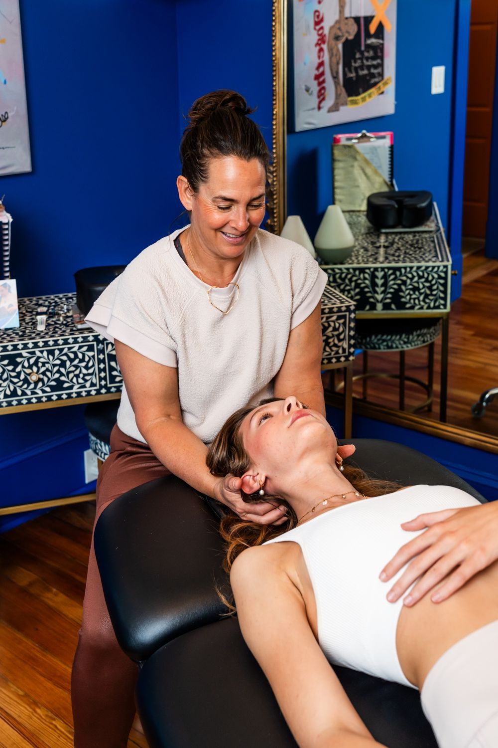 Therapeutic manual therapy treatment being performed in office with bright blue walls.