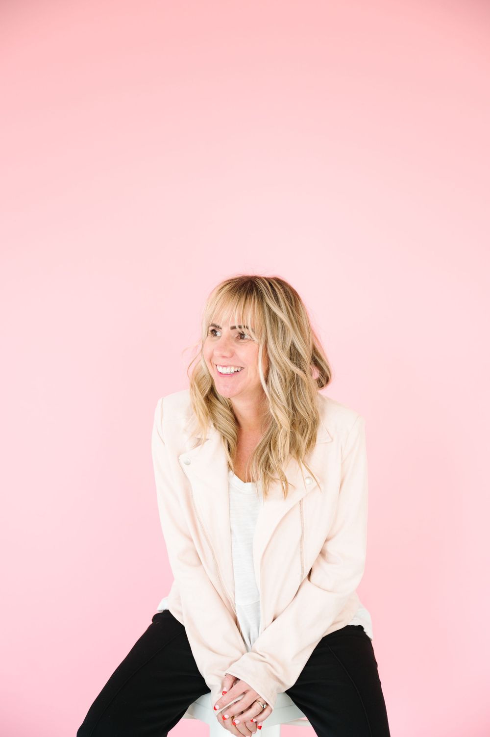 Professional headshots against pink backdrop featuring white blazer and black outfit combinations.
