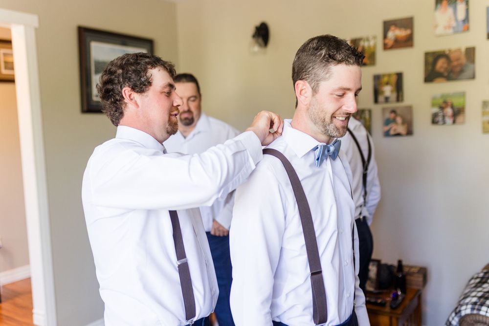 Men in white shirts and ties gathered in a room with photos displayed on the walls.