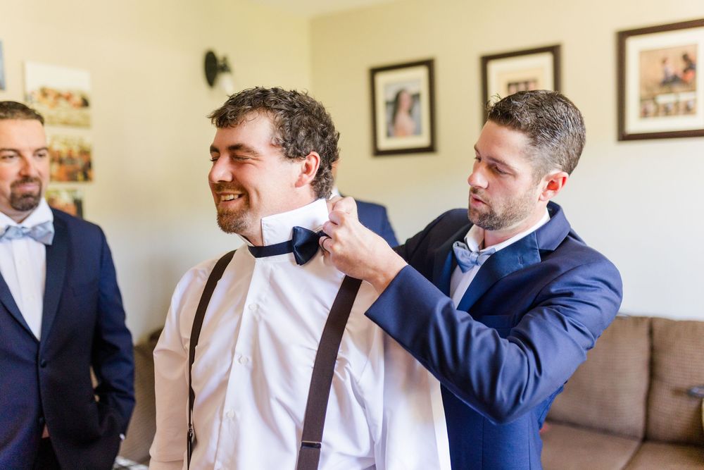 A series of candid moments showing someone adjusting a blue bowtie in a rustic indoor setting.