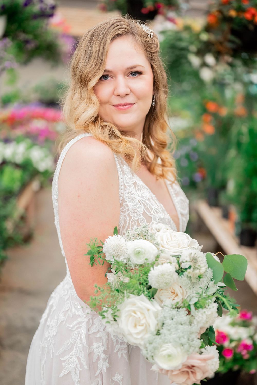 A wedding photo showing a white bridal bouquet with roses and greenery against a colorful garden background.