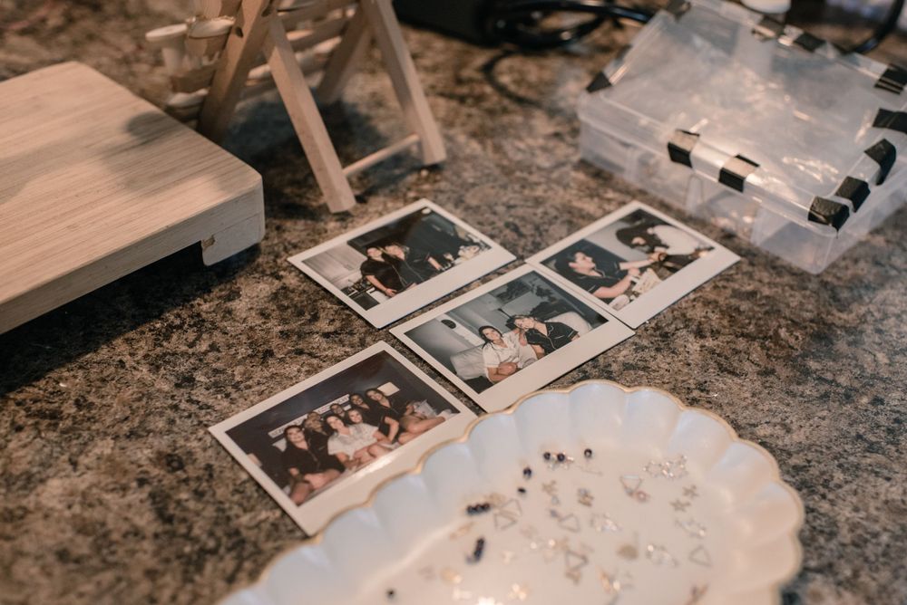 Vintage polaroid photos scattered on a textured surface with blurred objects in the background.