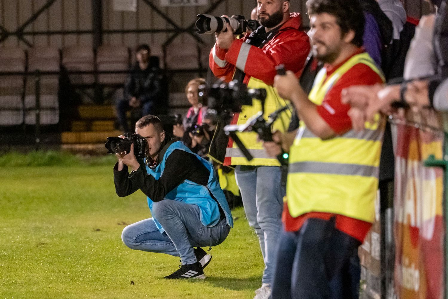 Photographers with professional cameras capture action from the sidelines.