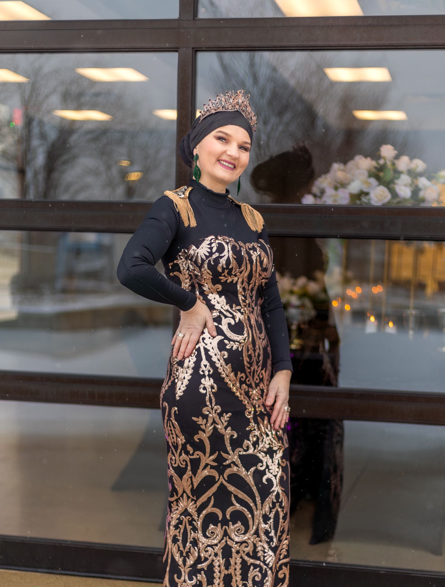 Elegant formal gown with copper and black design patterns worn with matching crown.