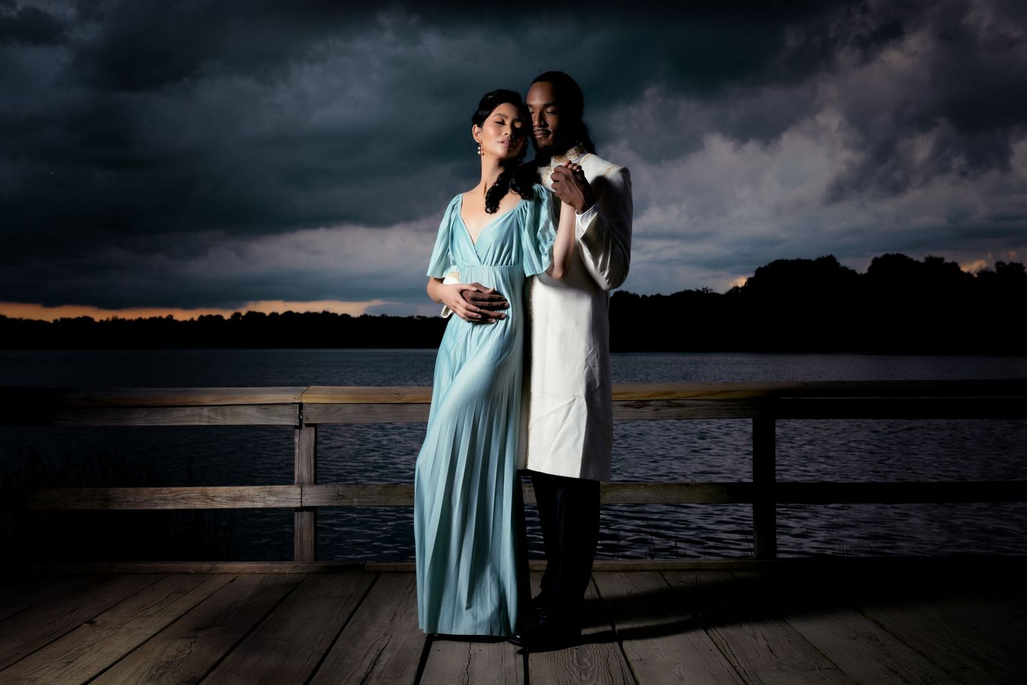 Romantic couple photo session at sunset on wooden dock by the water.
