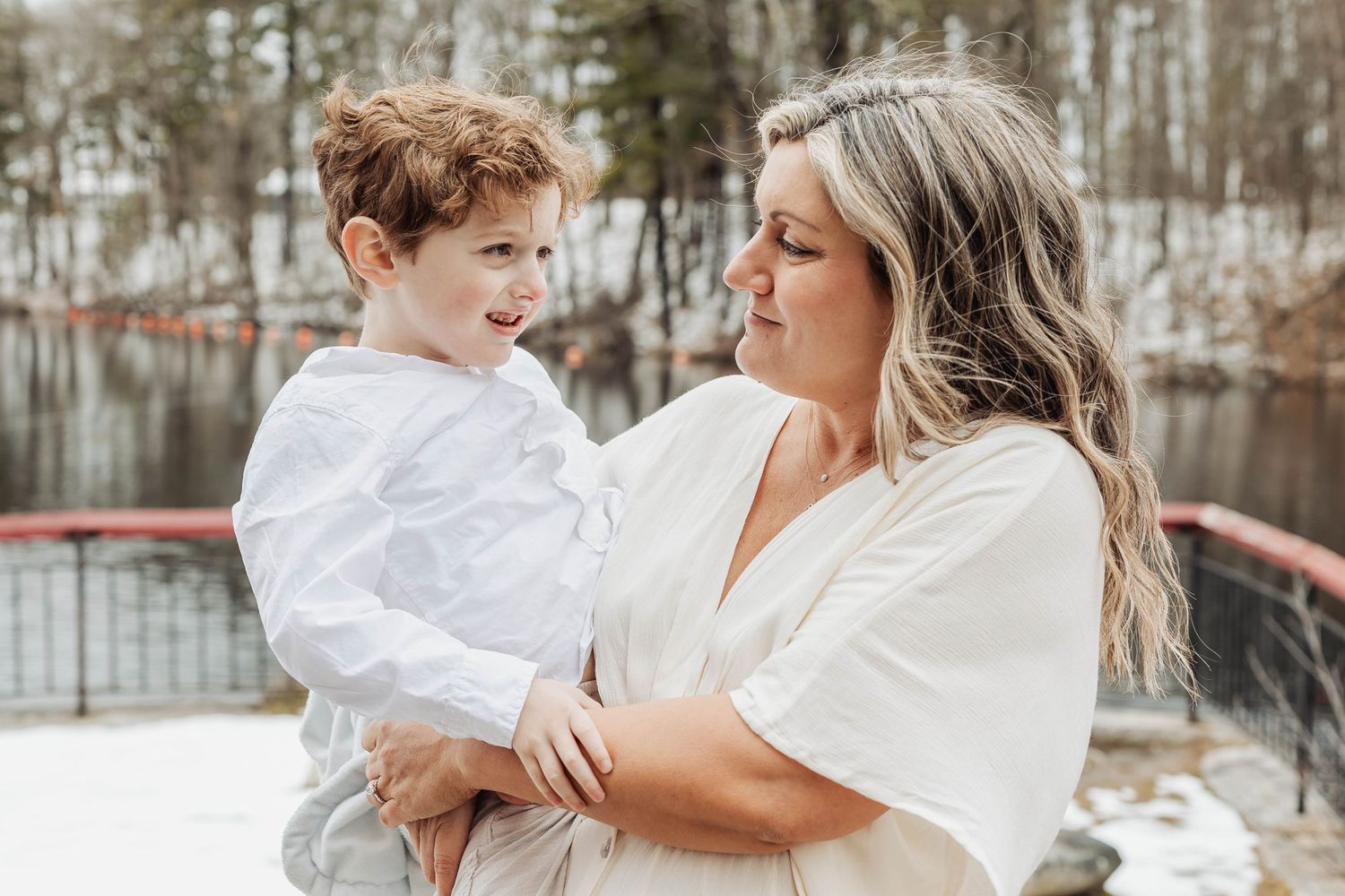 A tender moment shared between parent and child on a winter deck by the water.