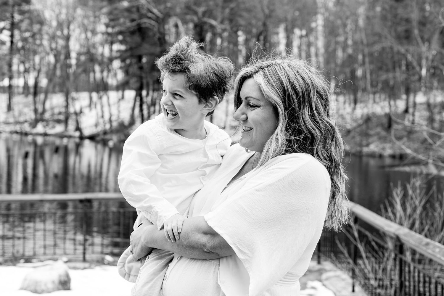 Black and white portrait capturing an intimate moment between parent and child outdoors.