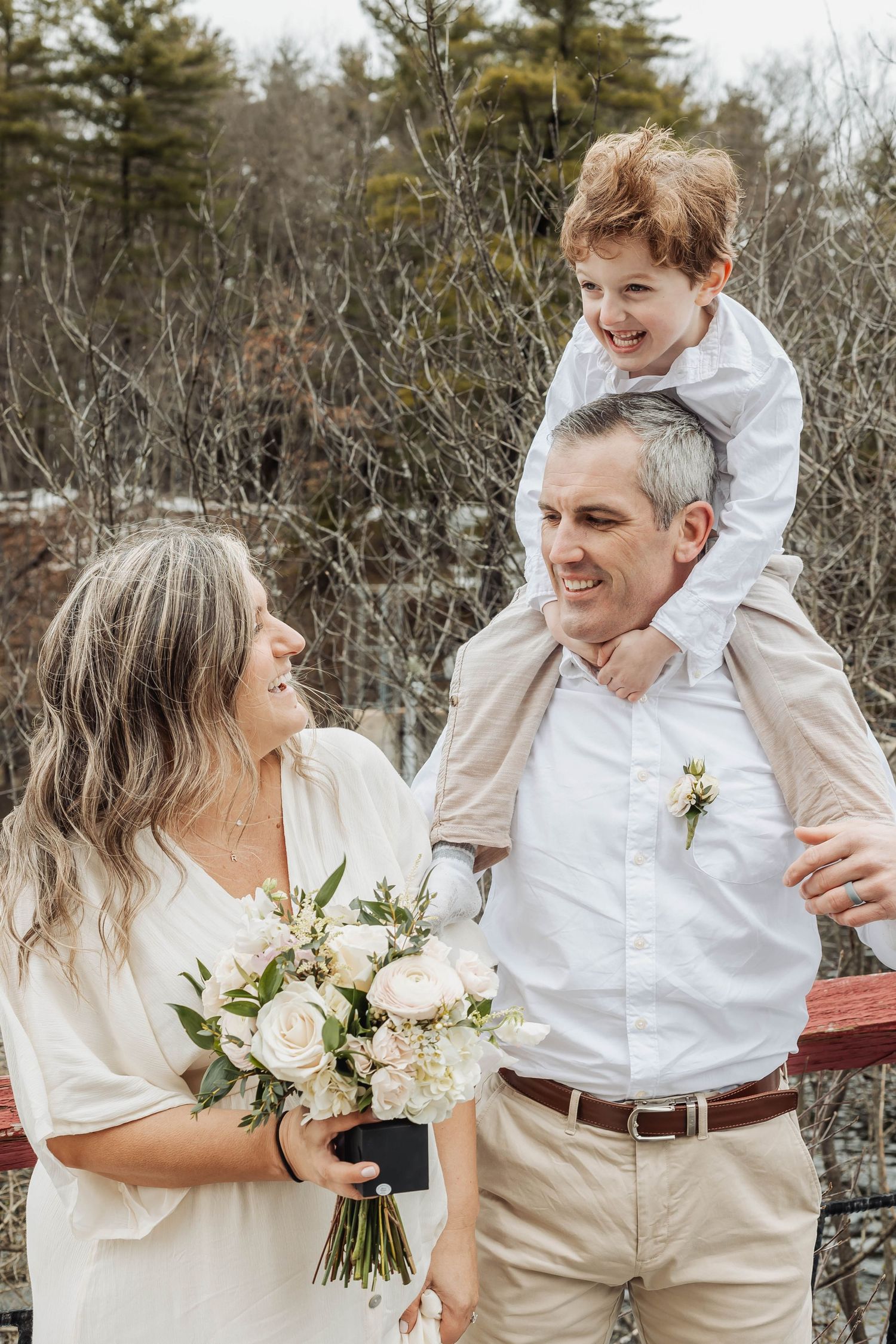 A joyful family moment on a winter day with white floral bouquet by the lake.