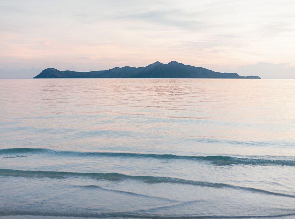 Amanpulo, Philippines: crystal-clear waters, island view and sunset sky.