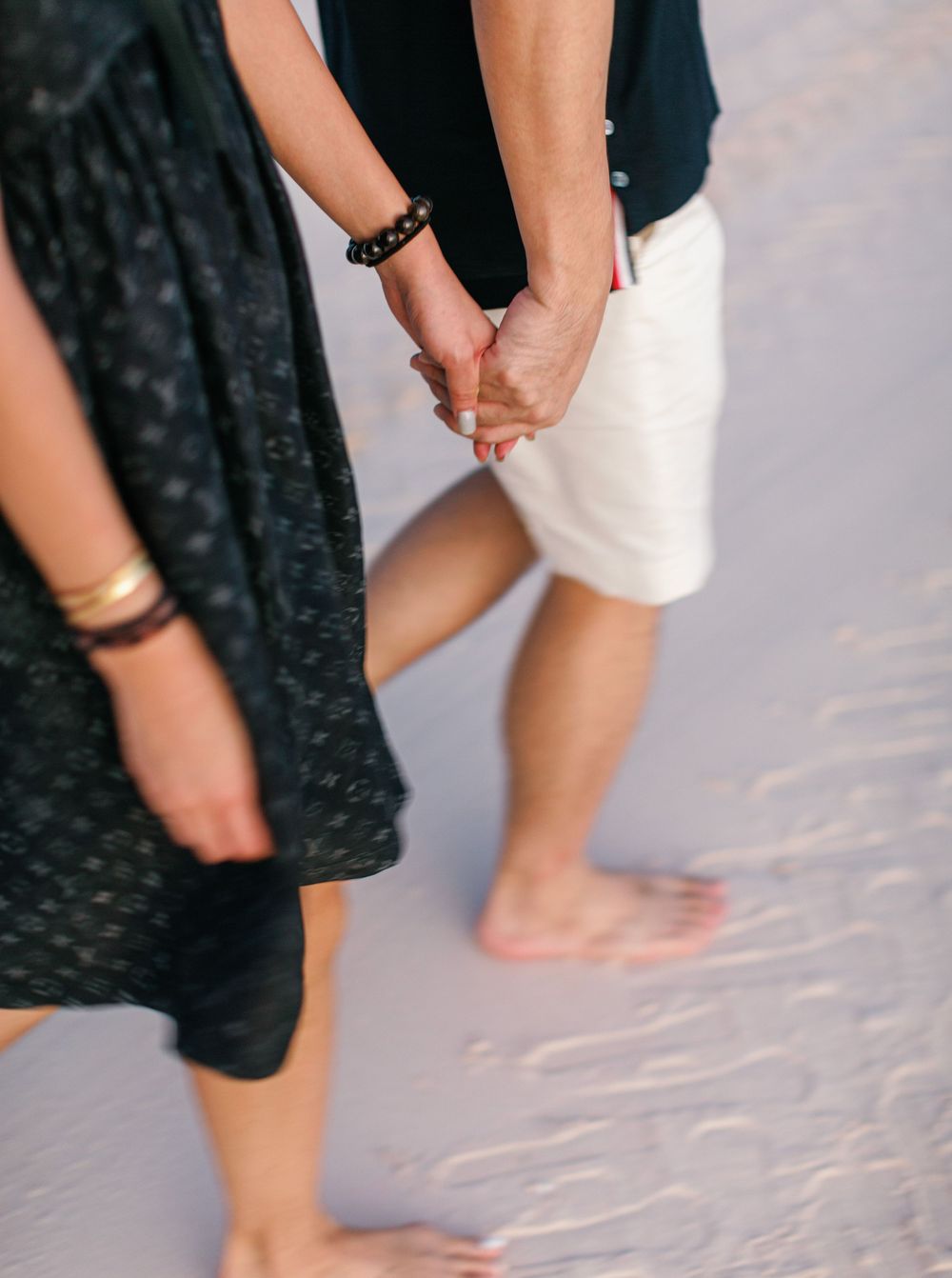 Couple walking by the shore at Amanpulo beach, Philippines.
