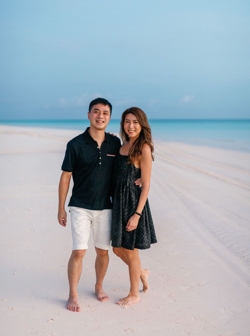 A beautiful couple, the bride and groom, standing on a beach in Amanpulo, Philippines, enjoying their time together.