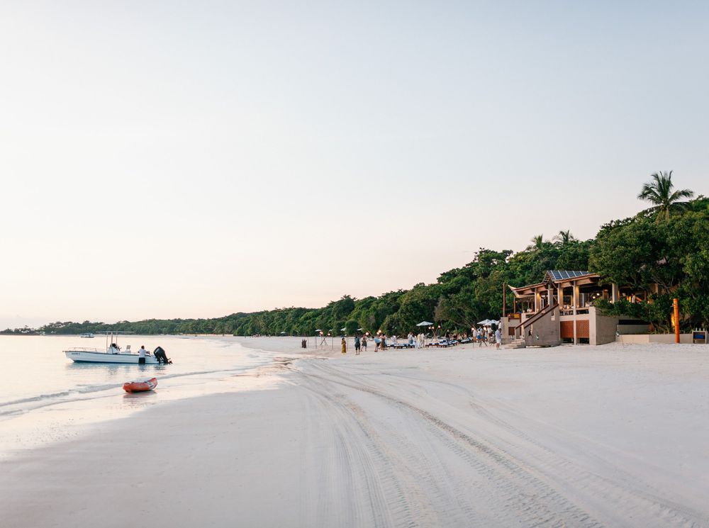 Scenic view of boat and cocktail on Amanpulo beach.