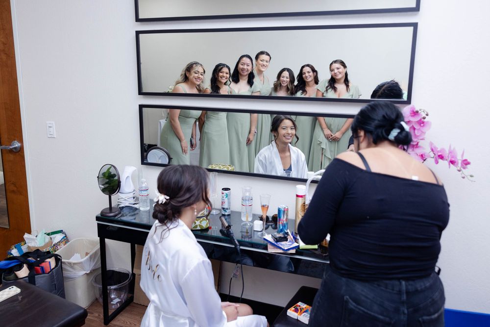 Bride getting ready with bridesmaids watching in mirror lakeside pavilion, northern california wedding photographer