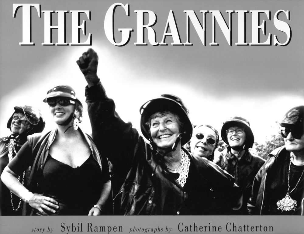 Black and white image of smiling protesters with helmets and raised fists, titled The Crannies.