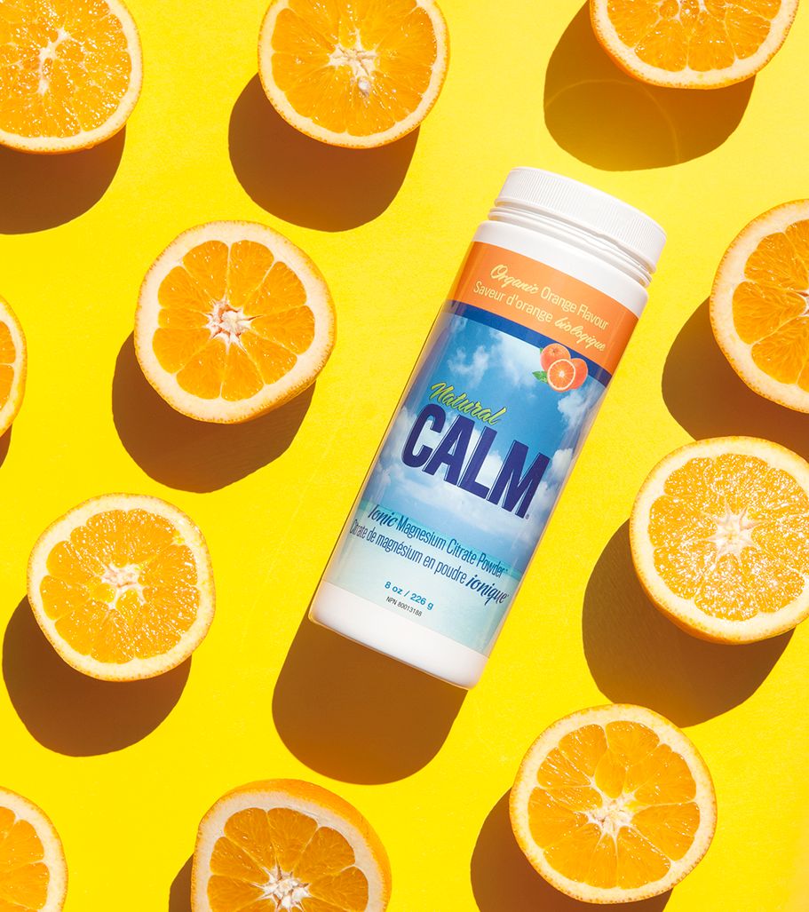Orange slices and wellness drink on bright yellow background in flat lay composition.
