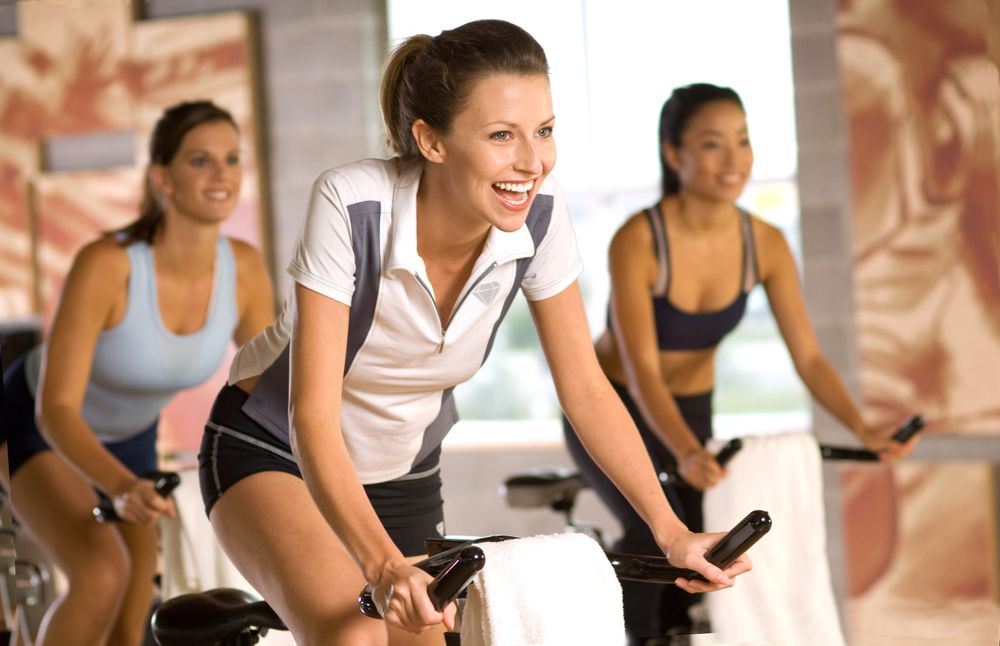 Group workout session on stationary bikes in a fitness studio.