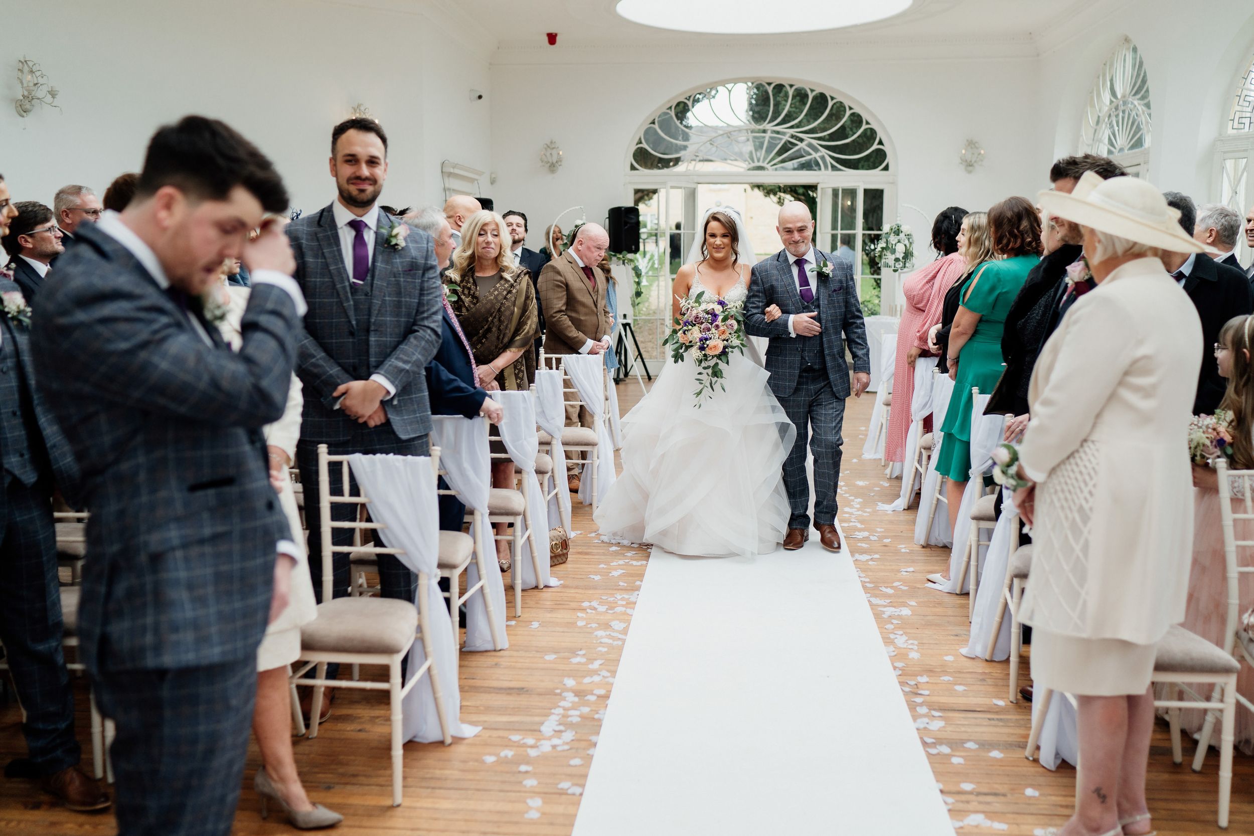 Wedding ceremony in progress with emotional reactions in bright indoor venue.