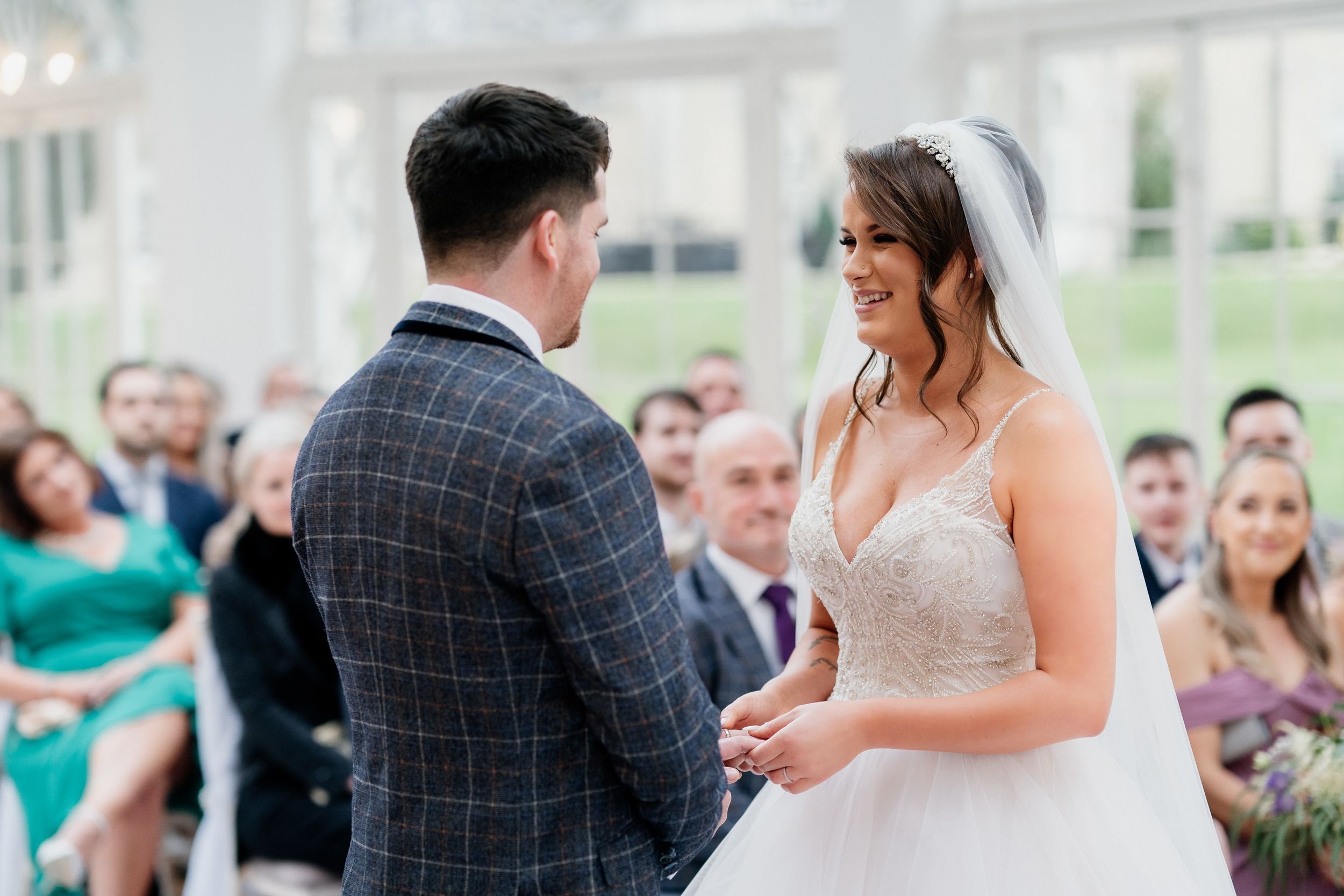 A tender moment captured during a wedding ceremony as the couple exchanges vows in an elegant indoor venue.