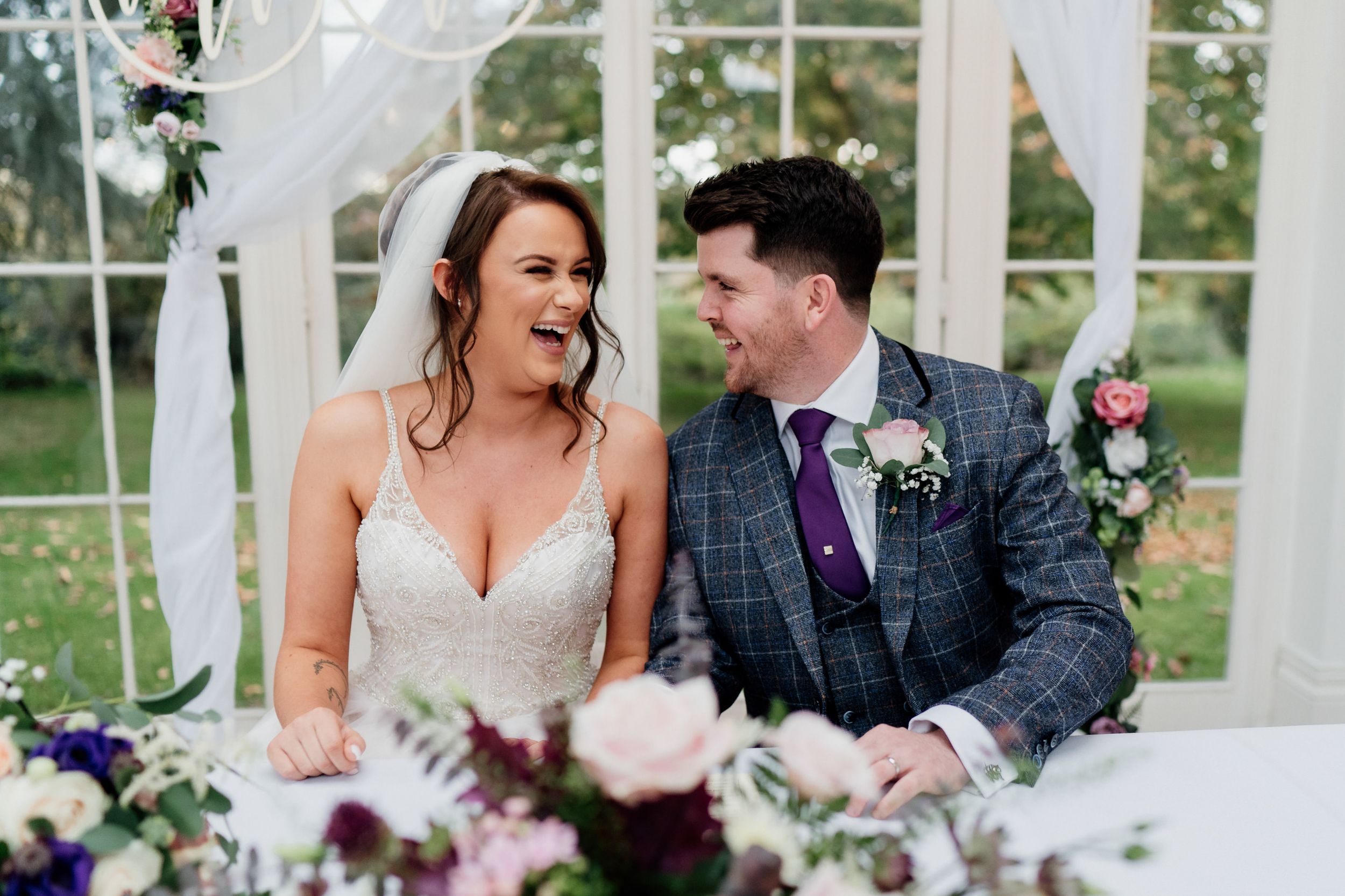 Candid moment at a wedding reception showing joyful laughter and celebration.