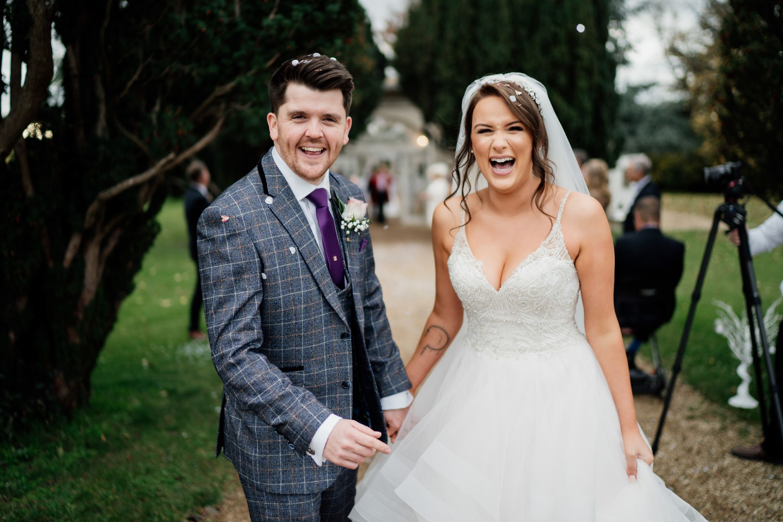 Joyful moment captured during a wedding celebration at Barton Hall on a garden pathway.