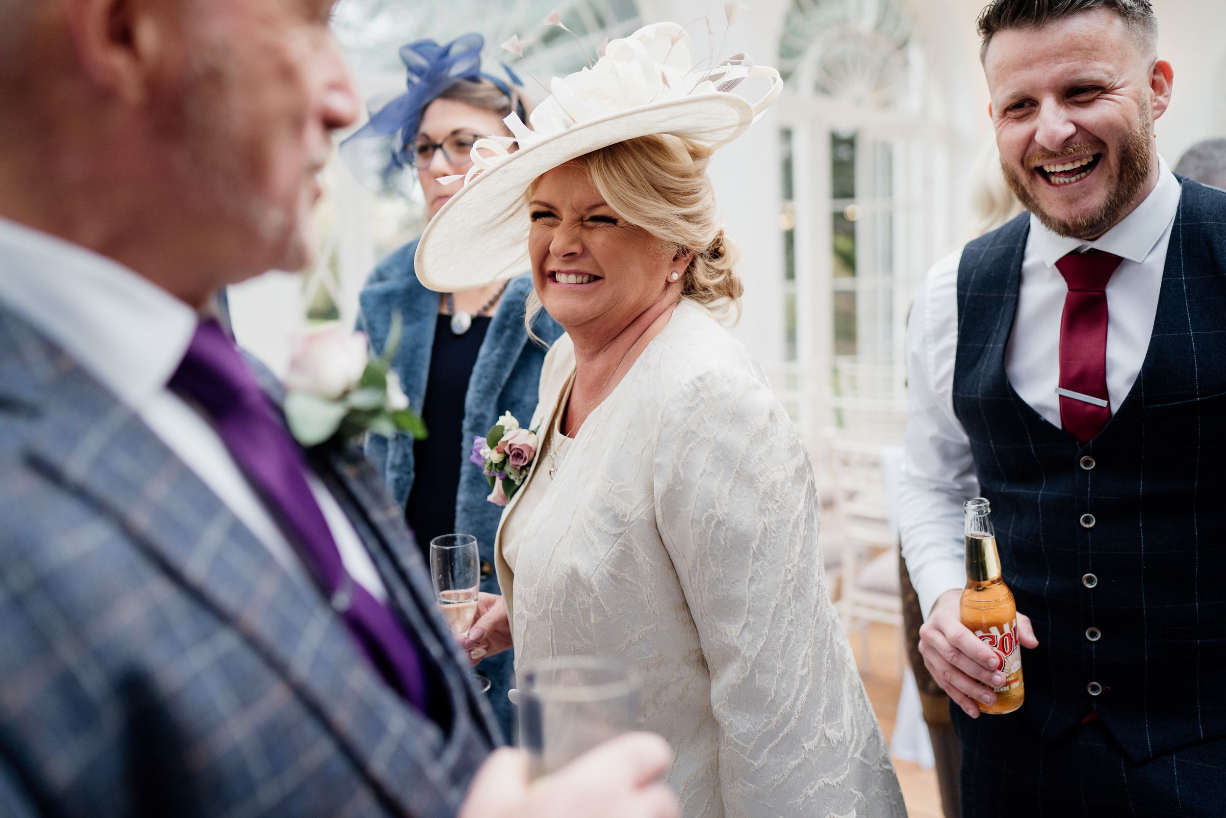Wedding guests share a lighthearted moment during an elegant indoor celebration.