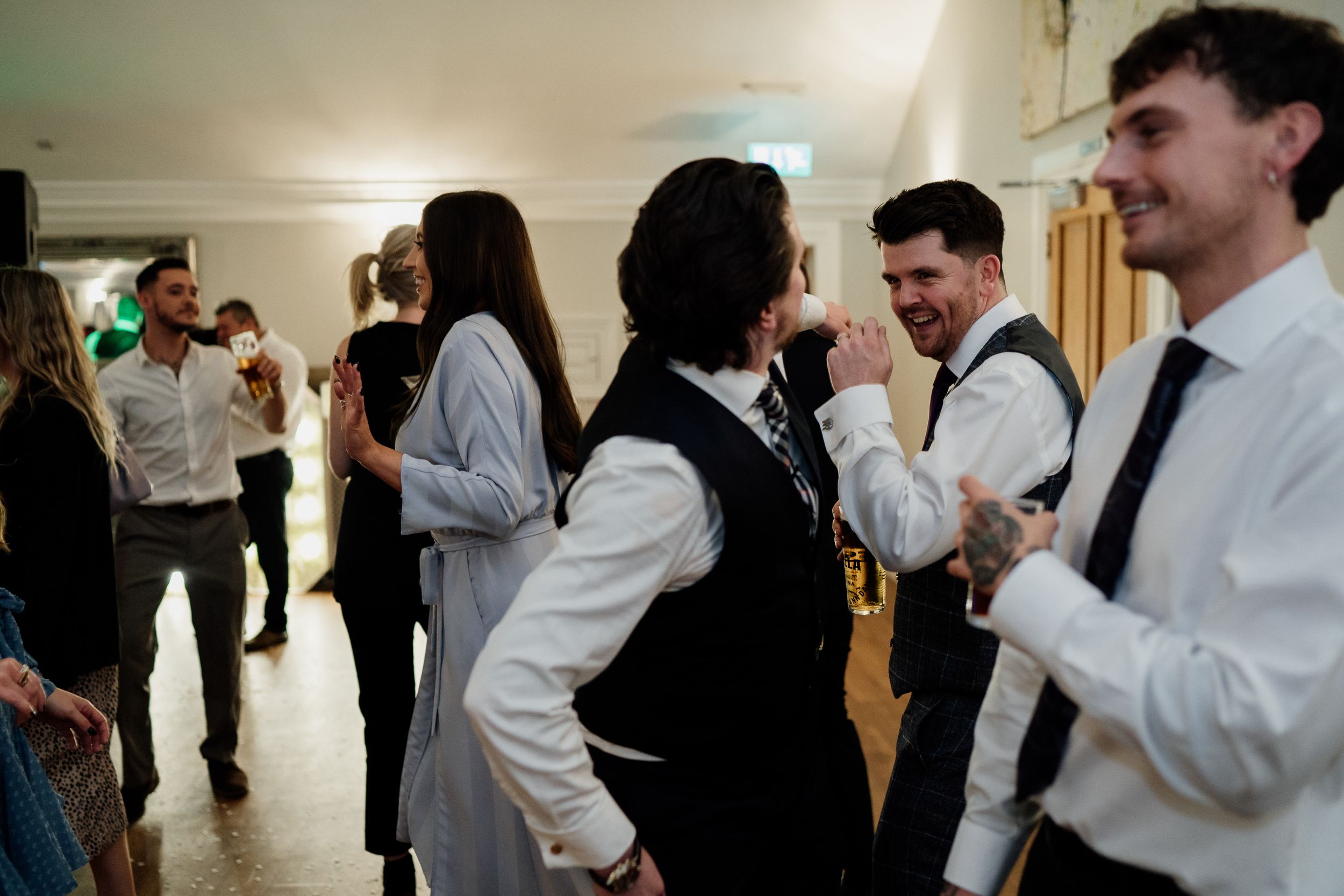 Wedding guests socializing in formal attire during the reception.