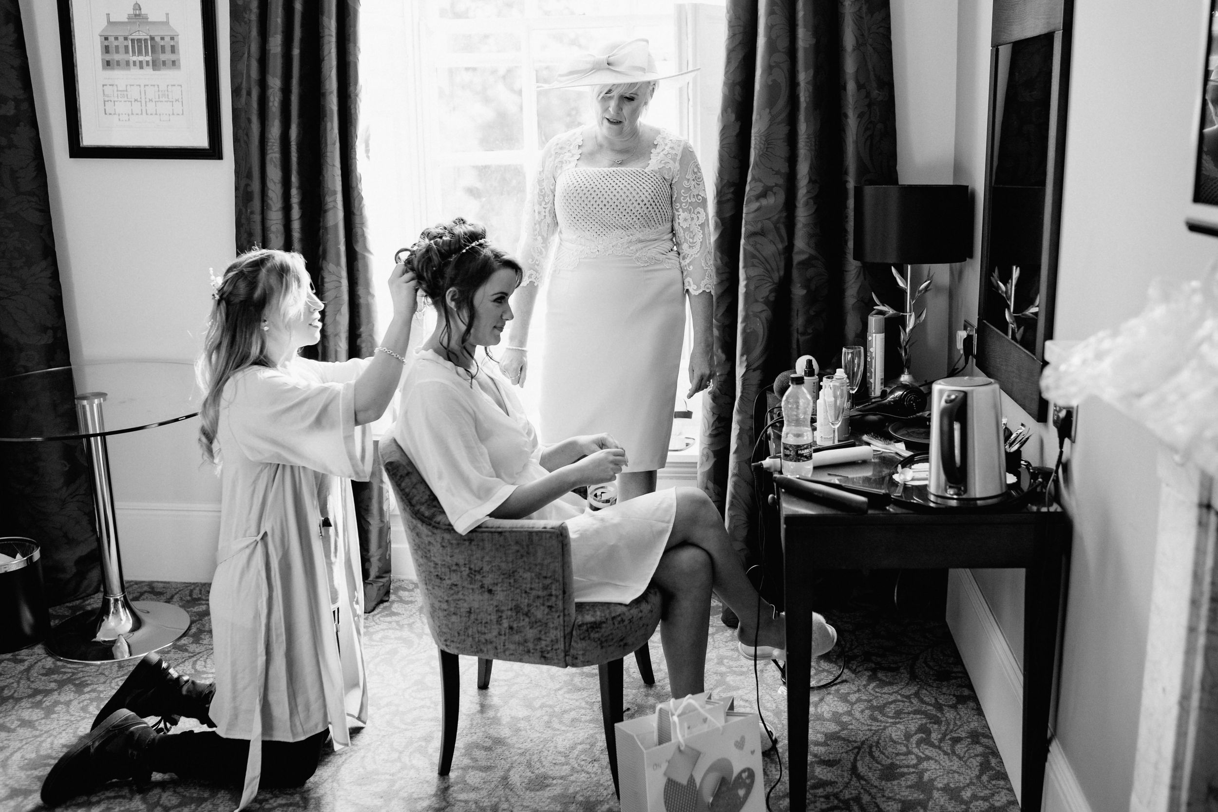 Black and white capture of wedding morning preparations in an elegant dressing room.