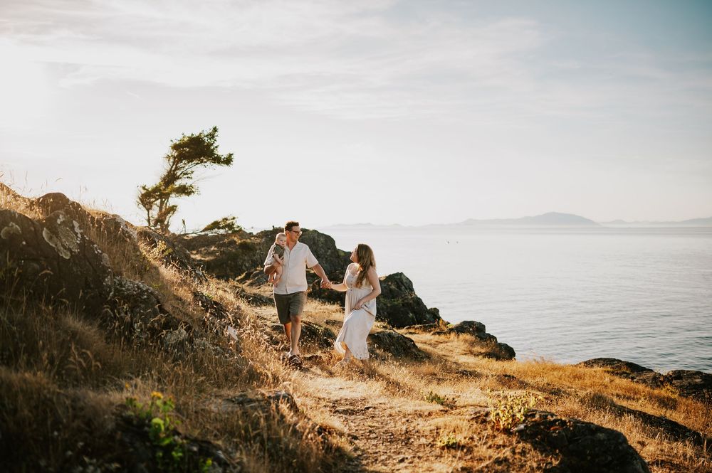 Candid photo of family walking on rocky bluff Neck Point Park Nanaimo during golden hour family photography by Vancouver Island photographer