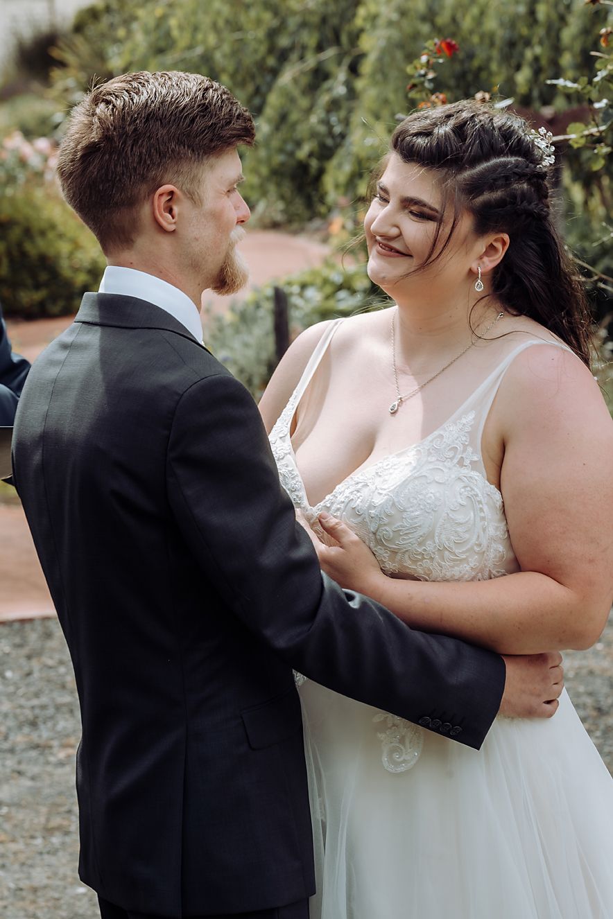 A tender moment between newlyweds as they dance together in an outdoor garden setting during their wedding celebration.