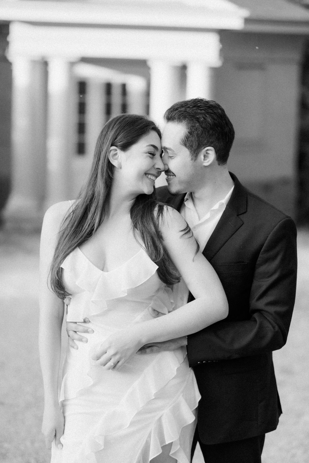 A series of black and white romantic couple poses showing an intimate embrace at a venue with columns.