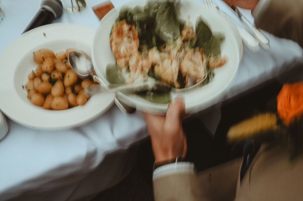 Blurry overhead view of table settings with plates of food including chickpeas and other dishes.