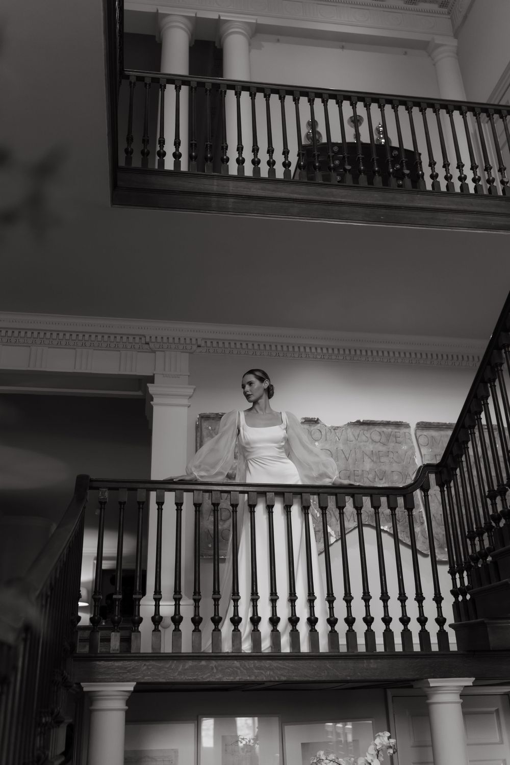 Elegant historical interior with white balustrade and spiral staircase featuring classic architectural details in black and white.