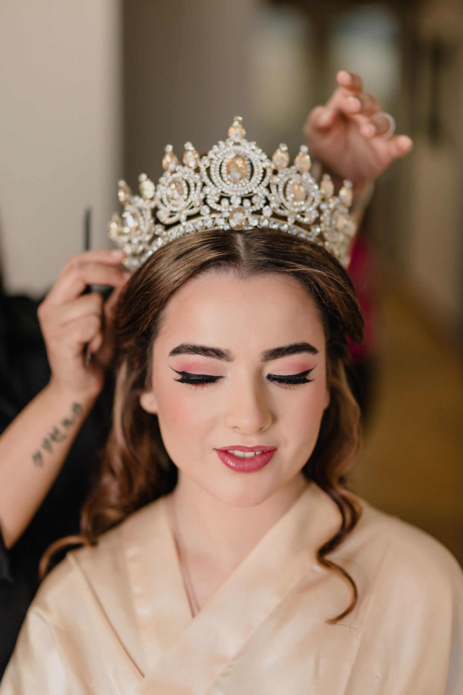Close-up of bridal beauty preparation showing detailed crown placement and soft romantic makeup.