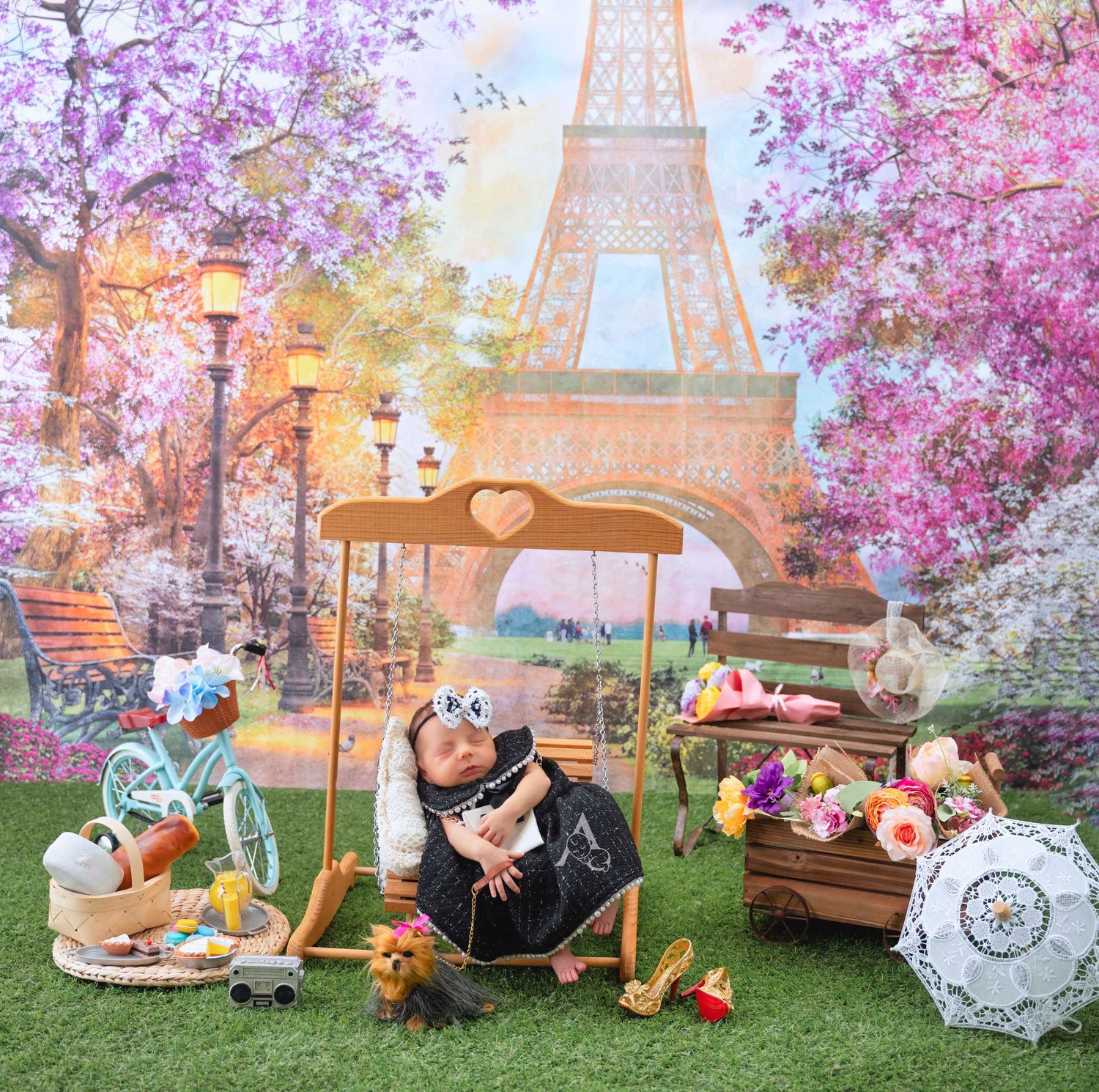 Whimsical Paris-themed baby photo with Eiffel Tower backdrop and cherry blossoms in spring.