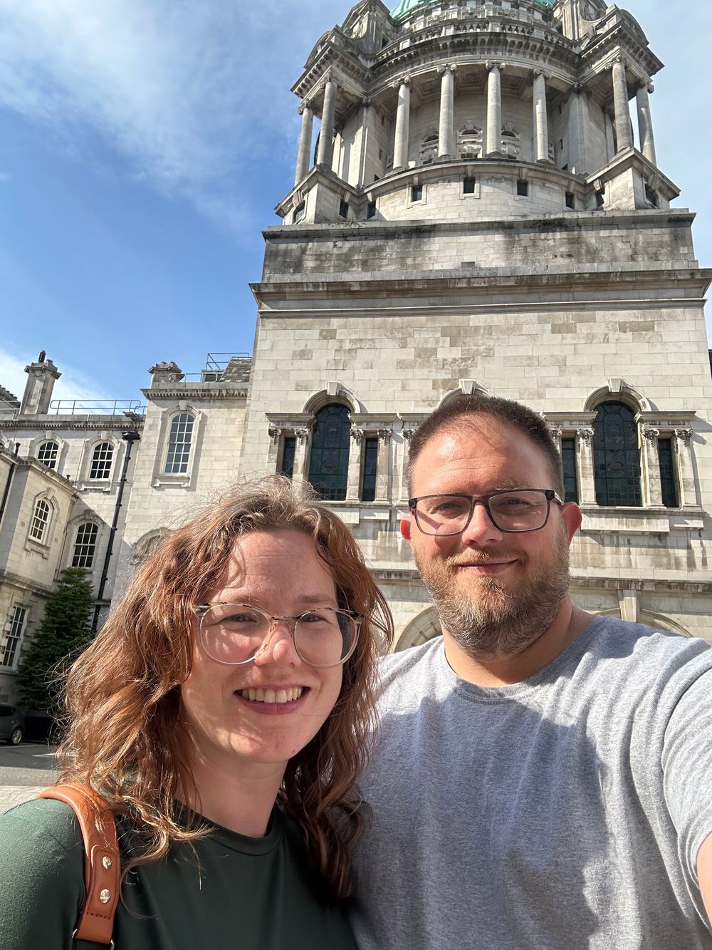 A selfie taken in front of Belfast City Hall's grand Victorian architecture on a sunny day.