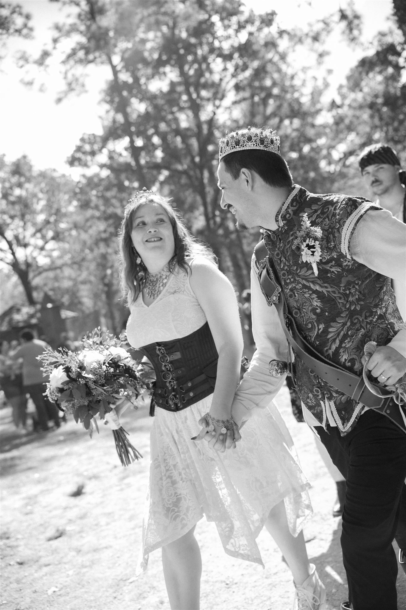 Black and white photo series showing playful moments of a couple celebrating their wedding in an outdoor garden setting.