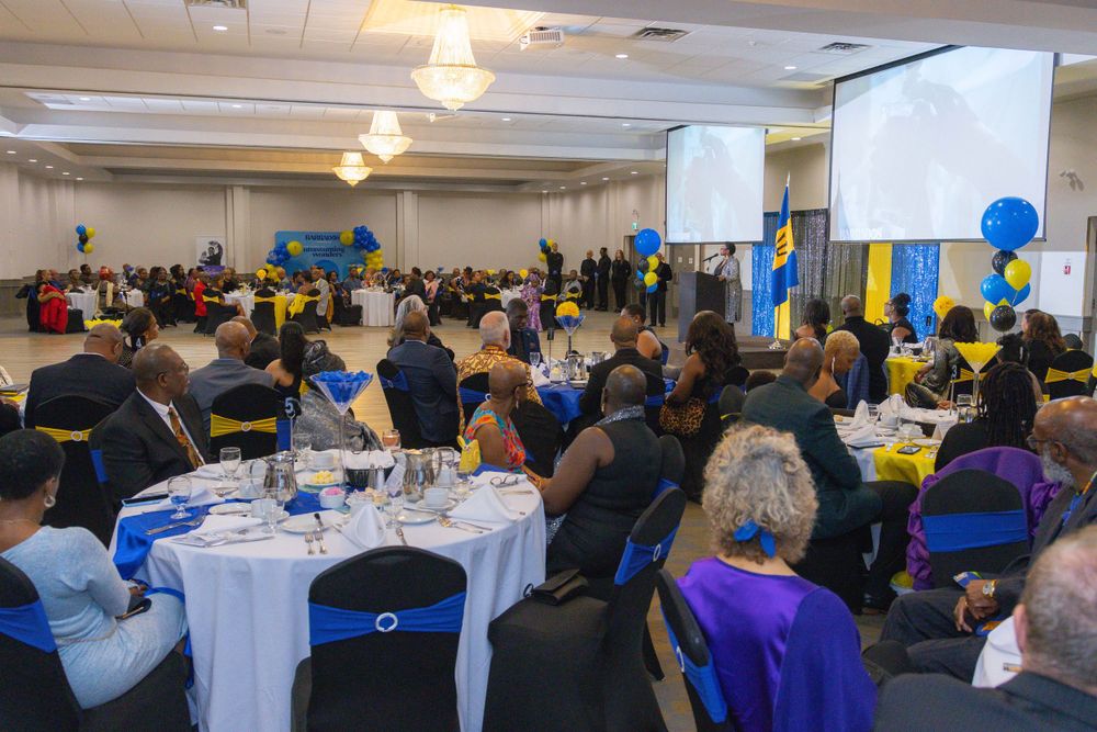 A formal banquet setup with round tables and blue and yellow decorations in a large hall.