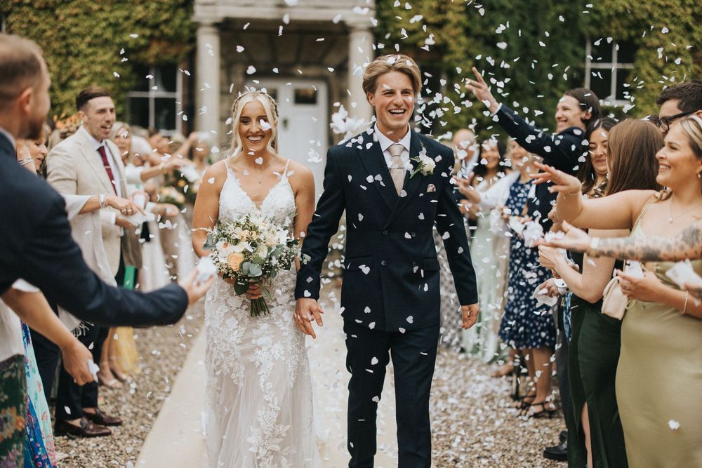 Wedding guests shower the newlyweds with confetti during their joyous wedding ceremony recessional.