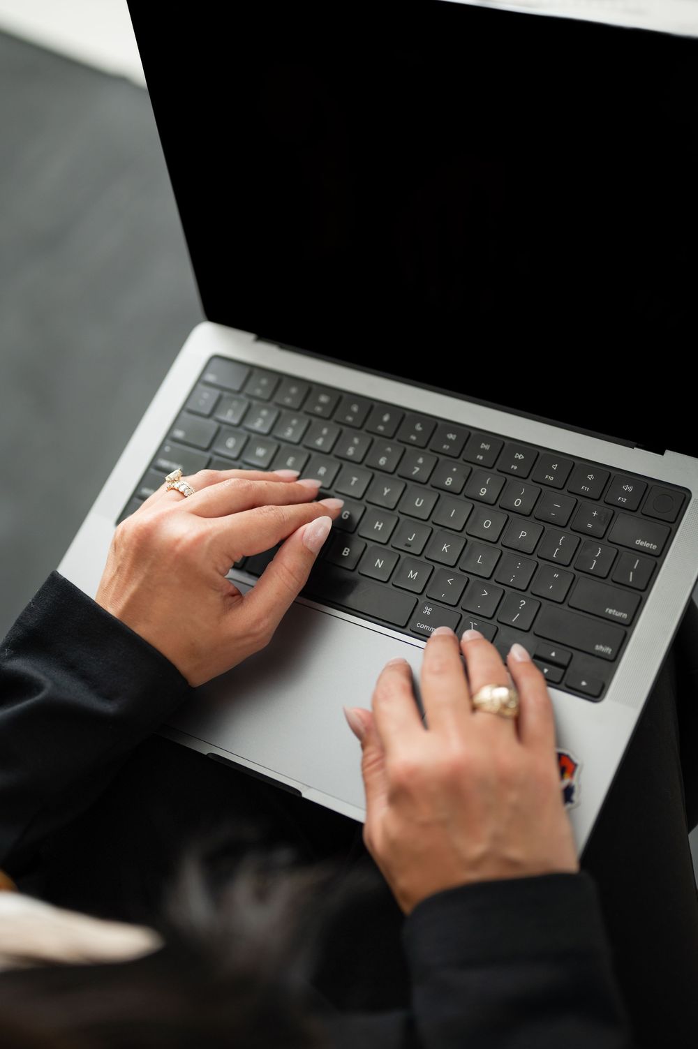 A sequence of close-up shots showing hands typing on a laptop keyboard with silver metallic finish.