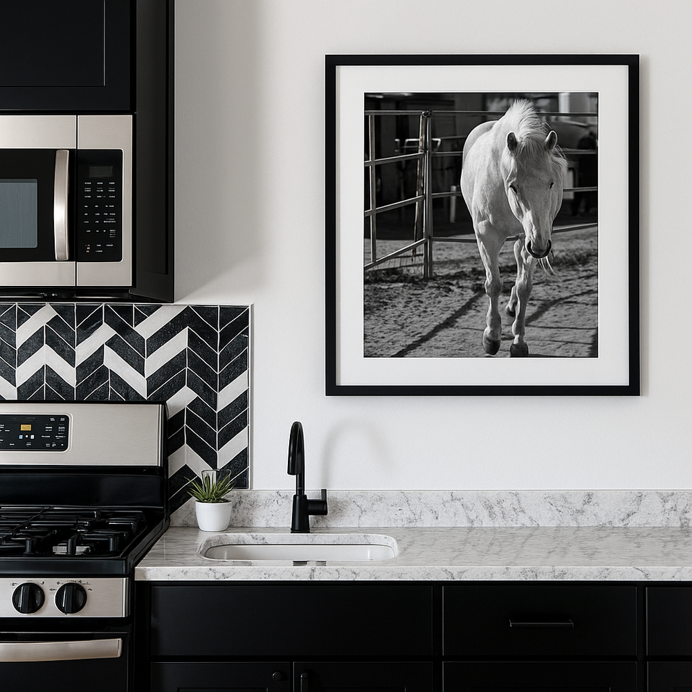 Modern gallery wall displaying black and white photographs and geometric art against white walls with marble accents.