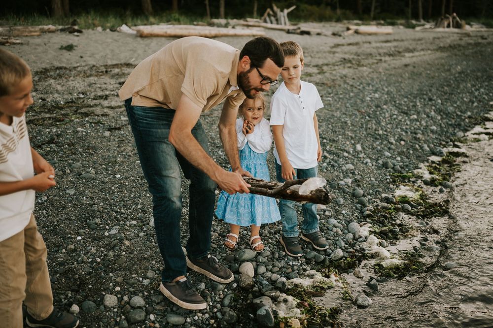 Comox Valley family photographer candid photo of kids playing seaweed at Kye Bay Beach portraits taken by photographer Soulfull Photographs