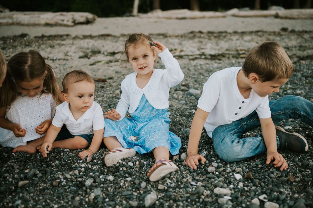 Comox Valley family photographer photoshoot of kids sitting in rocks Kye Bay Beach Portraits taken by photographer Soulfull Photographs