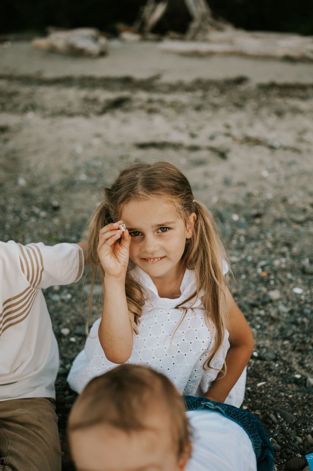 Comox Valley family photographer photoshoot of girl sitting in rocks Kye Bay Beach Portraits taken by photographer Soulfull Photographs