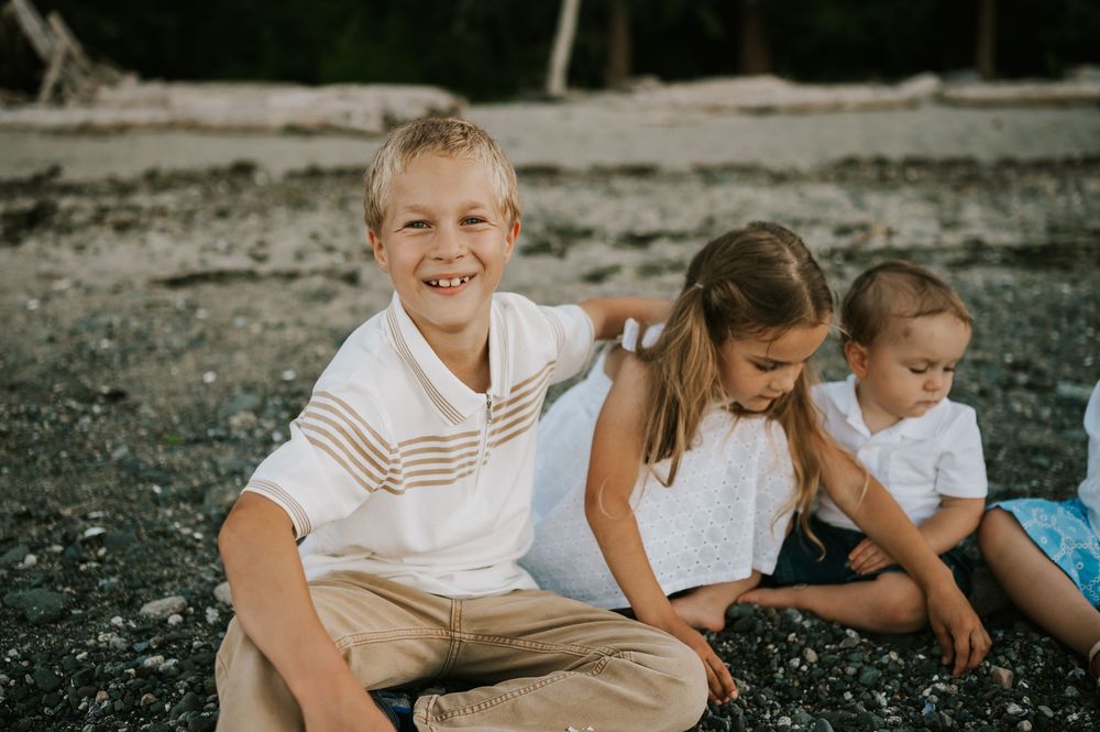 Comox Valley family photographer photoshoot of kids sitting in rocks Kye Bay Beach Portraits taken by photographer Soulfull Photographs