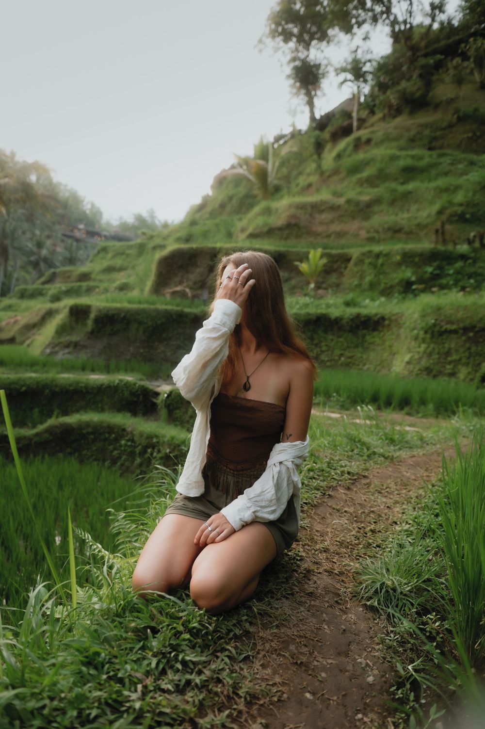 A visitor poses on the scenic Tegalalang rice terraces in Ubud, Bali surrounded by green stepped landscapes.