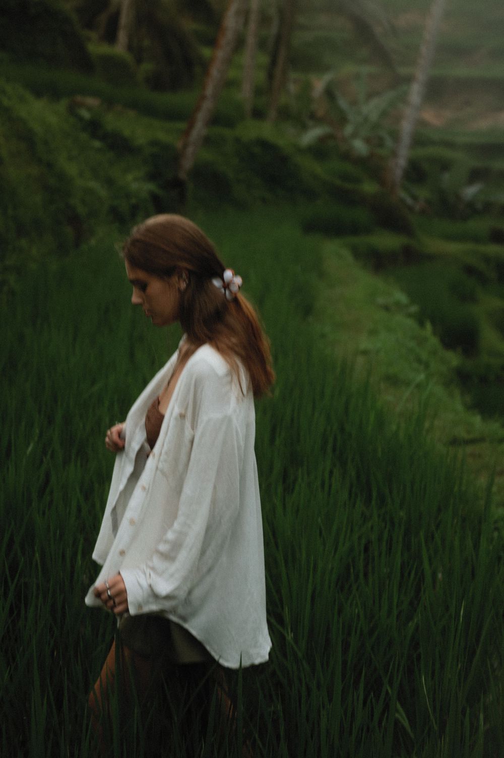A figure in white explores the scenic rice terraces and palm groves in an idyllic tropical landscape.