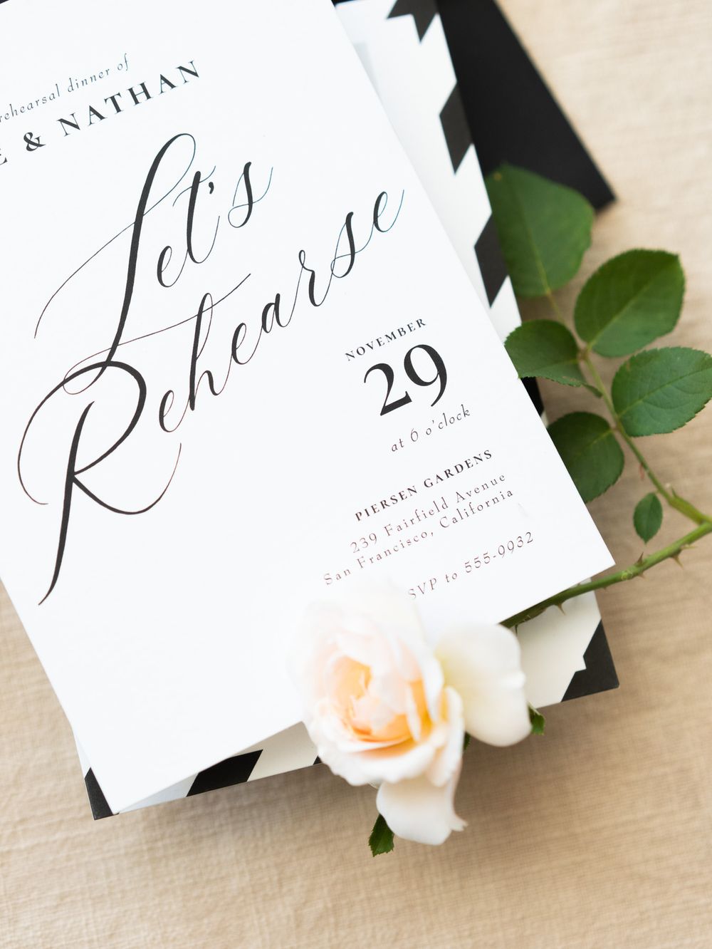 A wedding rehearsal dinner invitation with elegant calligraphy and a soft pink rose decoration.