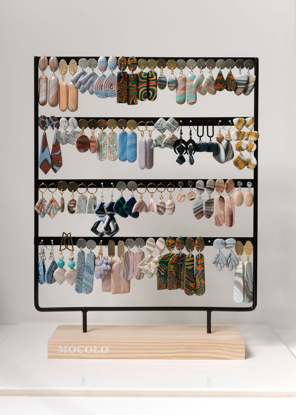 A modern retail display rack with multiple rows of colorful socks organized neatly on metal bars against a white background.