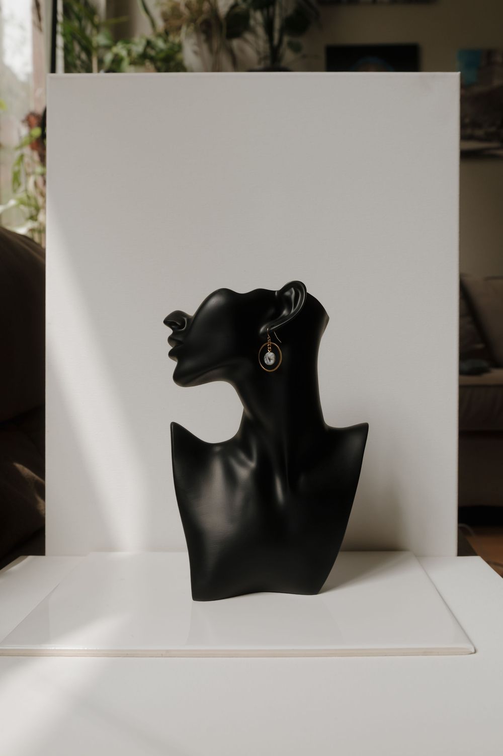 Black jewelry display bust on white background showcasing elegant silhouette against minimalist setting.
