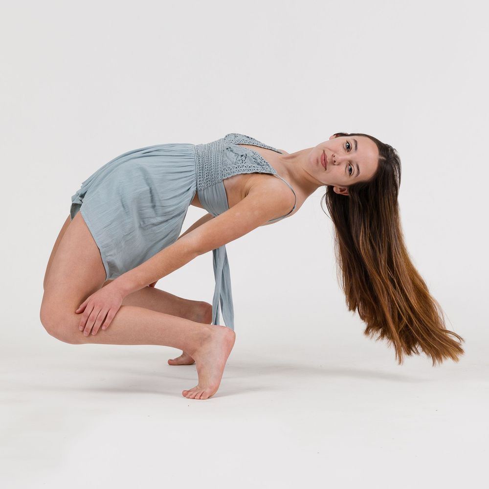 A high school girl hits a dramatic dance pose in a photography studio in Chandler, Arizona